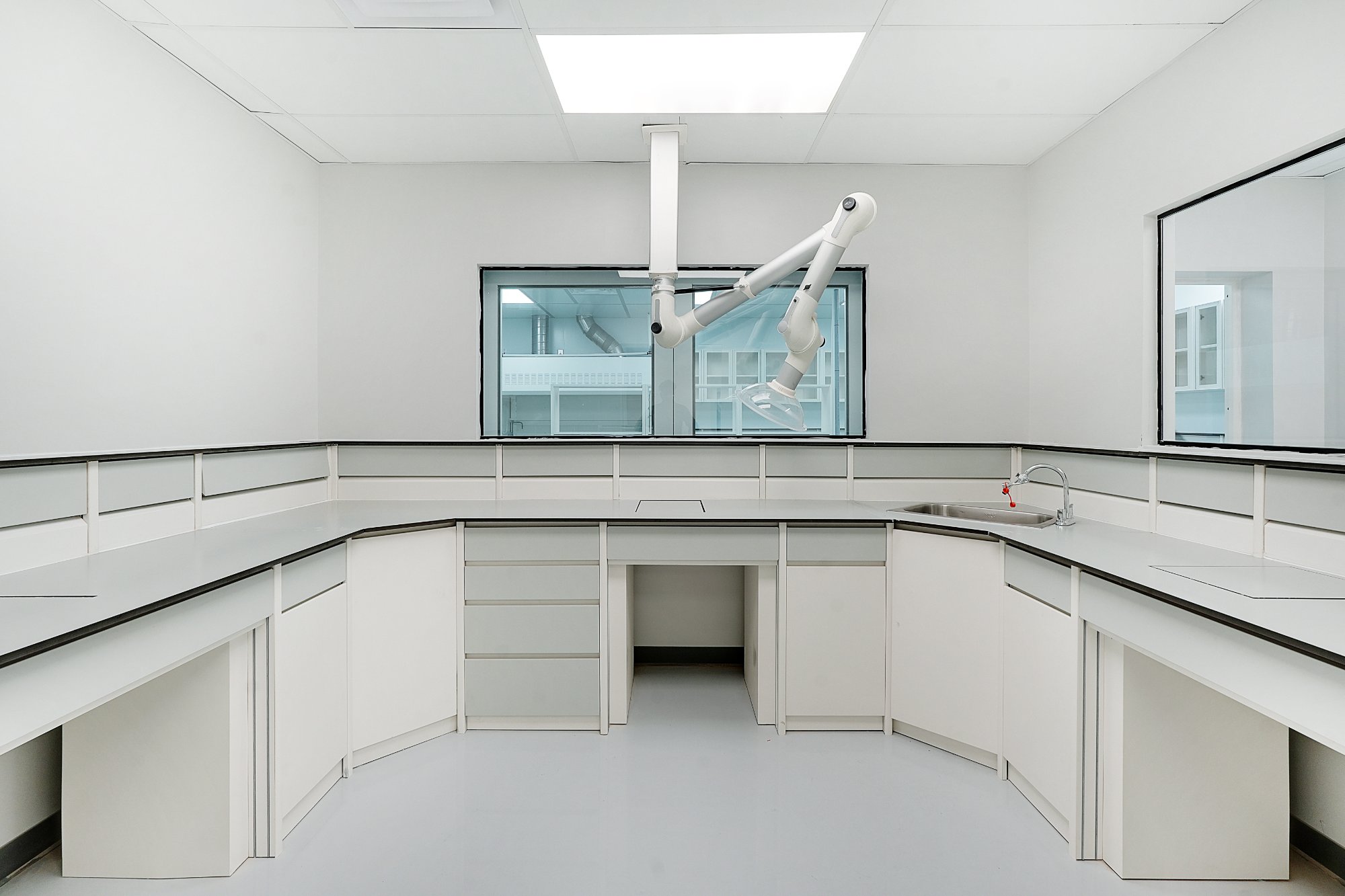 ACH Engineering modular laboratory — U-shaped bench layout with overhead robotic arm fixture and vision panel pass-through window