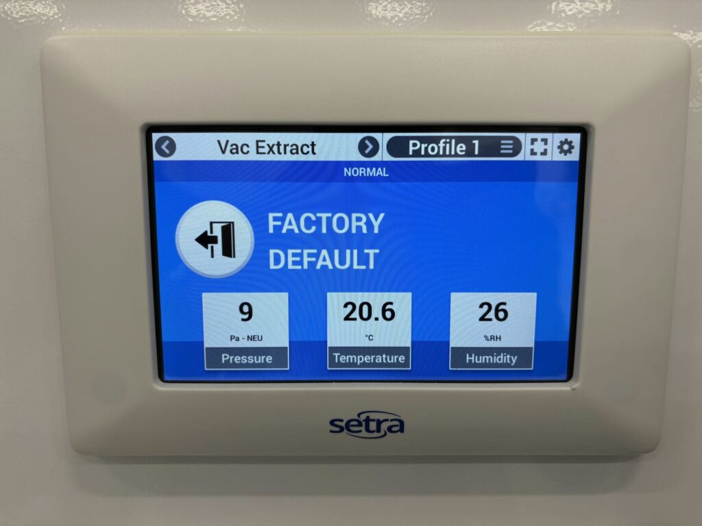 Cleanroom environment monitor displaying real-time pressure, temperature, and humidity readings used to measure energy efficiency against operating requirements