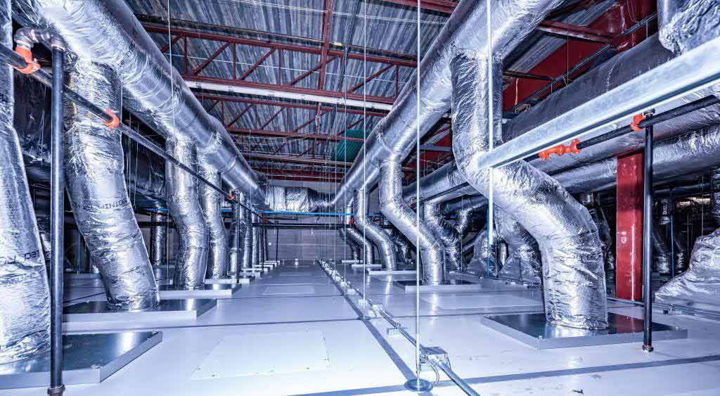 Insulated HVAC ductwork and filtration systems in a cleanroom mechanical interstitial space, representing the engineering systems where energy efficiency levers apply