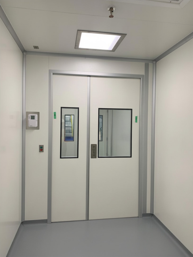 Double swing cleanroom doors with flush-mounted vision panels and magnetic interlock system controls.