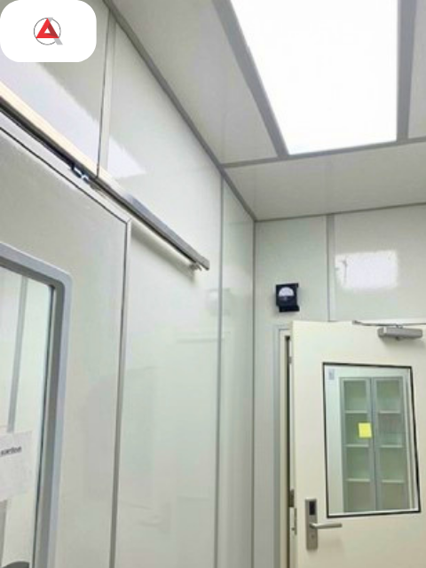 NAPRA compliant anteroom with wall-mounted differential pressure gauge and flush modular ceiling panels engineered by ACH Engineering
