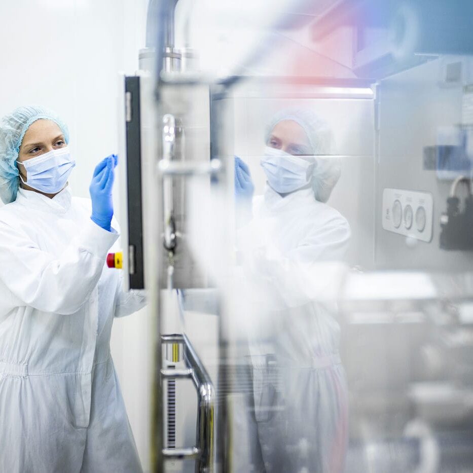 woman working in a pharmaceutical cleanroom woman working in a pharmaceutical cleanroom
